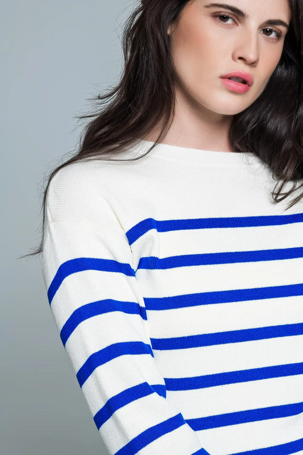 White sweater with buttons on shoulders and blue stripes